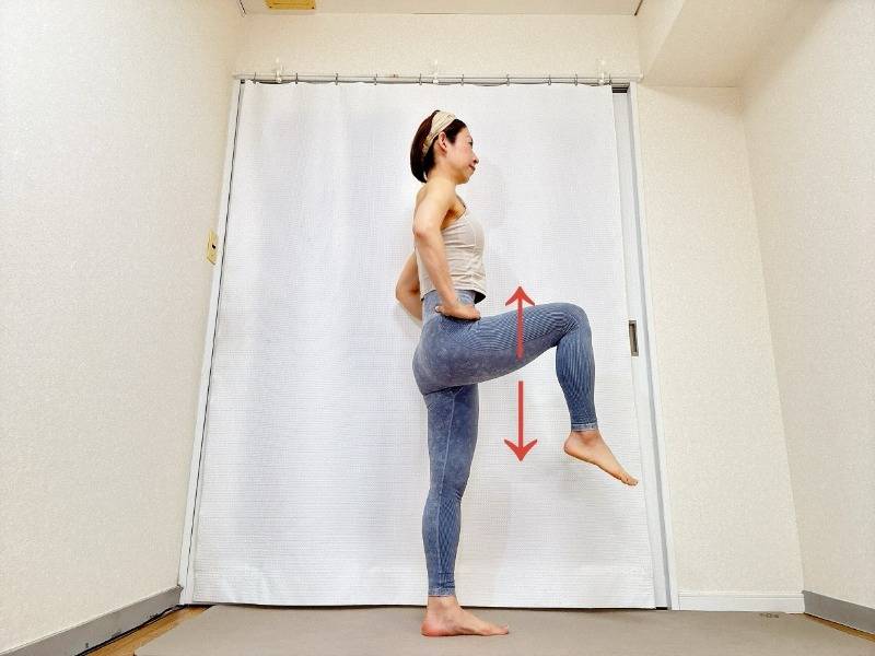 立って左膝を曲げ、腿を引き上げて腸腰筋を鍛えるエクササイズ