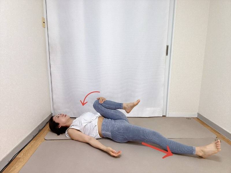 右膝を胸に寄せ、左脚を伸ばした仰向けの体勢