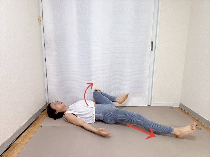 仰向けで左脚を伸ばし、右膝を胸に引き寄せ外に開いた内転筋のストレッチ