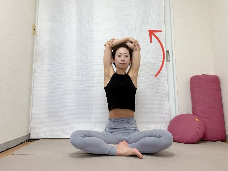 あぐらで座り、両肘を抱えて天井方向に引き上げた体勢