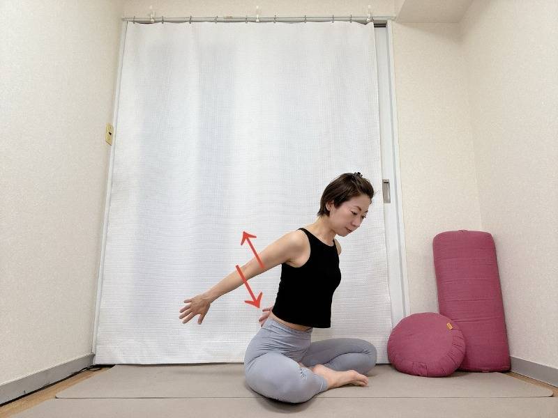 あぐらで座り、上体を目に傾け腕を後ろに伸ばして上下に動かす上腕三頭筋のエクササイズ