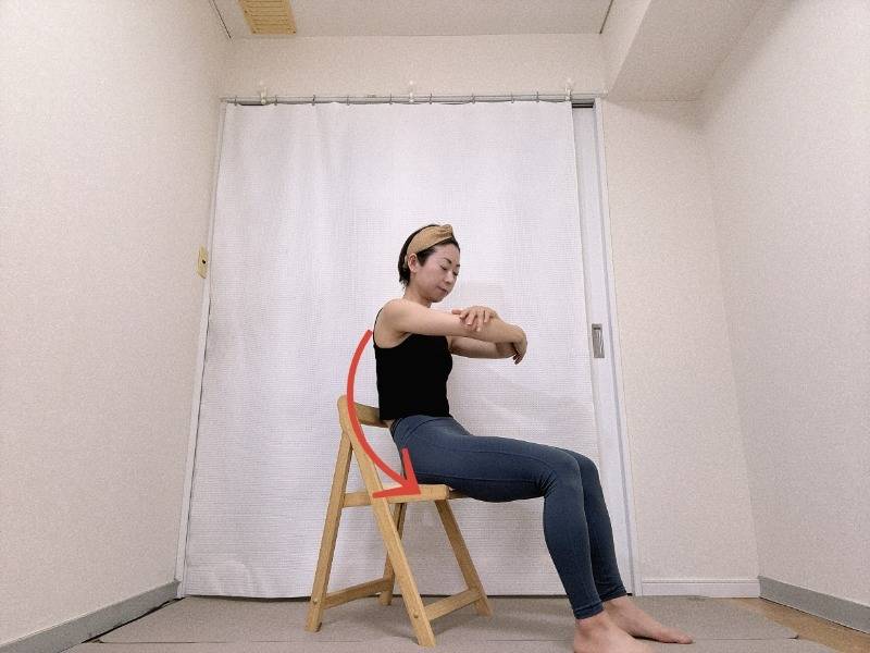 胸の前で肘を抱え、背中を軽く丸めて上体を後ろに倒した体勢