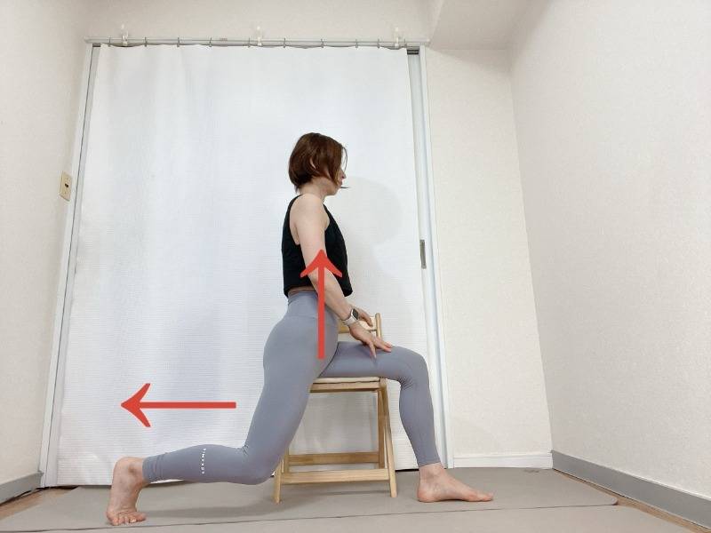 椅子の背もたれが体の右側にして横向きで座り、左脚を後ろに引いた体勢