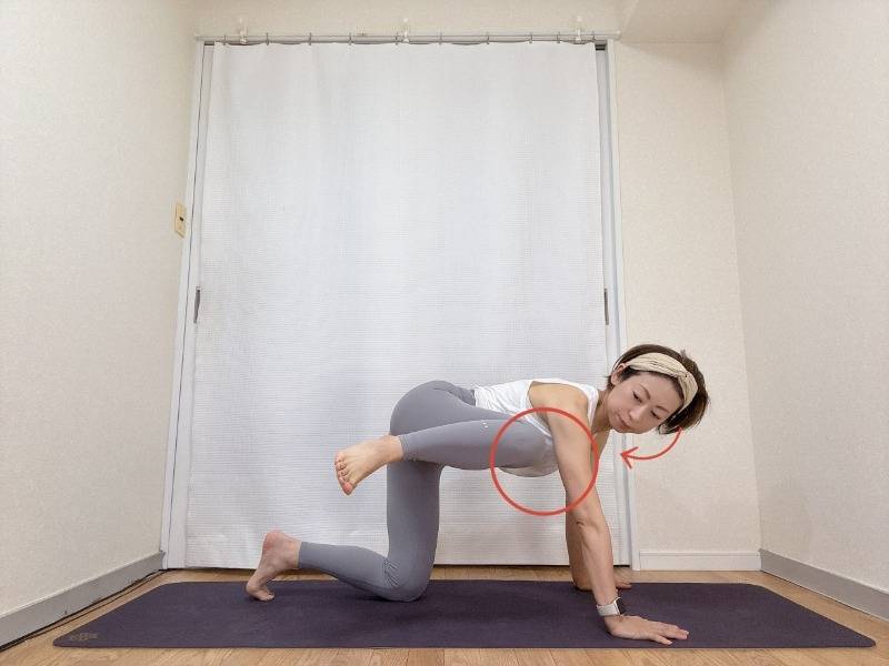 四つ這いから左膝を90度に曲げ、左脇へ寄せ、視線を左膝に向けて脇腹を縮めるエクササイズ