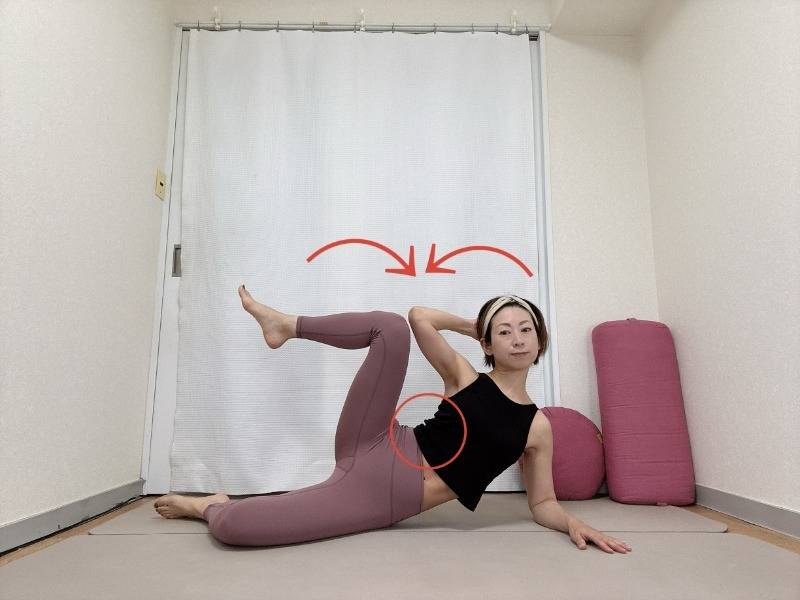 右肘を床について右に体を倒した横向き寝の姿勢から、左肘と左膝をタッチする脇腹の引き締めエクササイズ