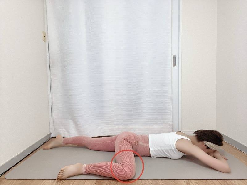 片膝を曲げてうつ伏せに寝た半分のカエルのポーズ