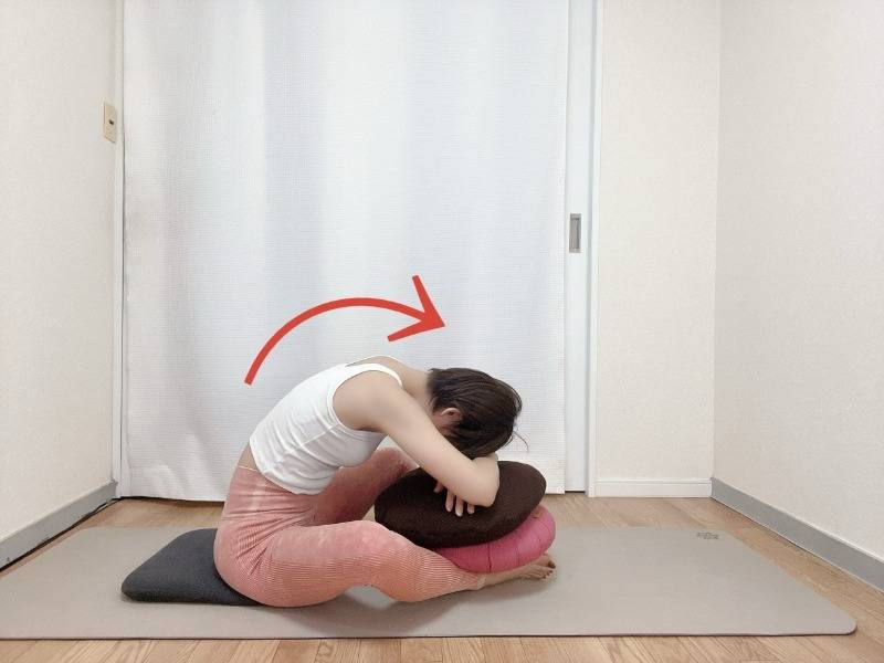 脚の上にクッションを置いて軽減したバタフライポーズ