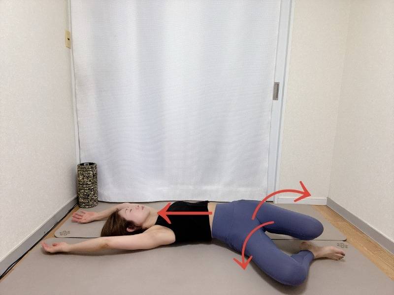 両手を頭上に伸ばした仰向けで両膝を左右交互に倒すストレッチ