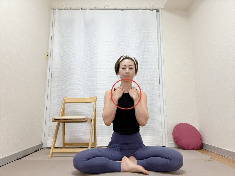 鎖骨に指先を引っ掛けてあぐらだ座った体勢