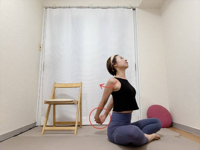 あぐらで座り、背中で両手を組んで胸を開くストレッチ