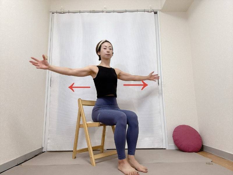 椅子に座り、両腕を左右に開いて胸を広げるストレッチ