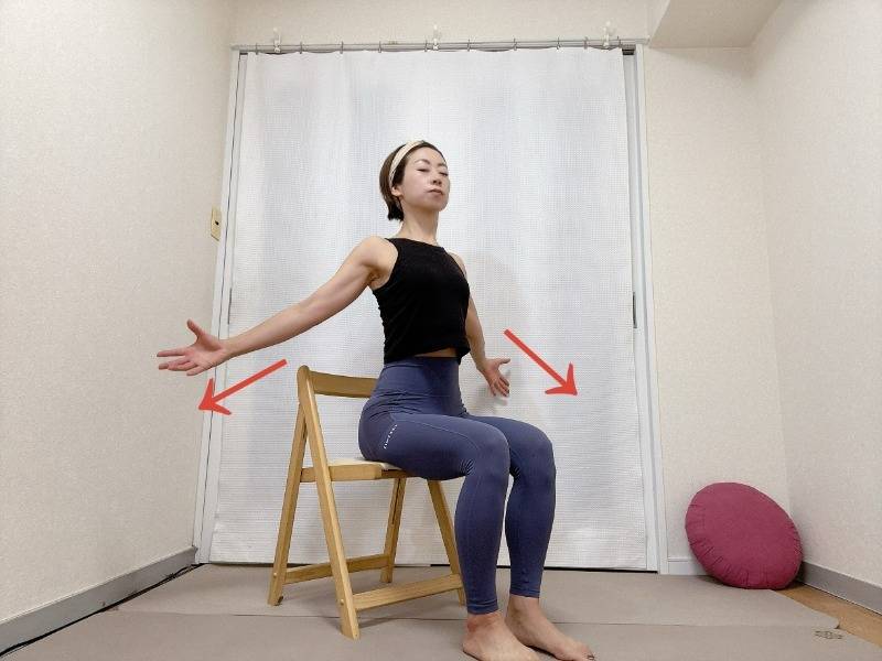 椅子に座り、腕を斜め下に広げて胸を開くストレッチ