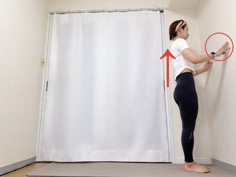 壁に両手をつき、背筋を伸ばして立った体勢