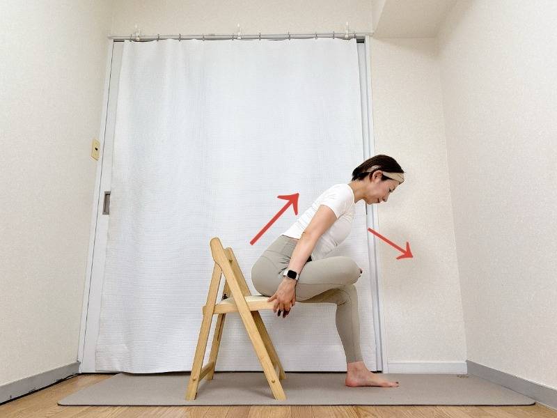 椅子に座り、左脚を右腿に乗せて4の字を作り、上体を前に倒すストレッチ