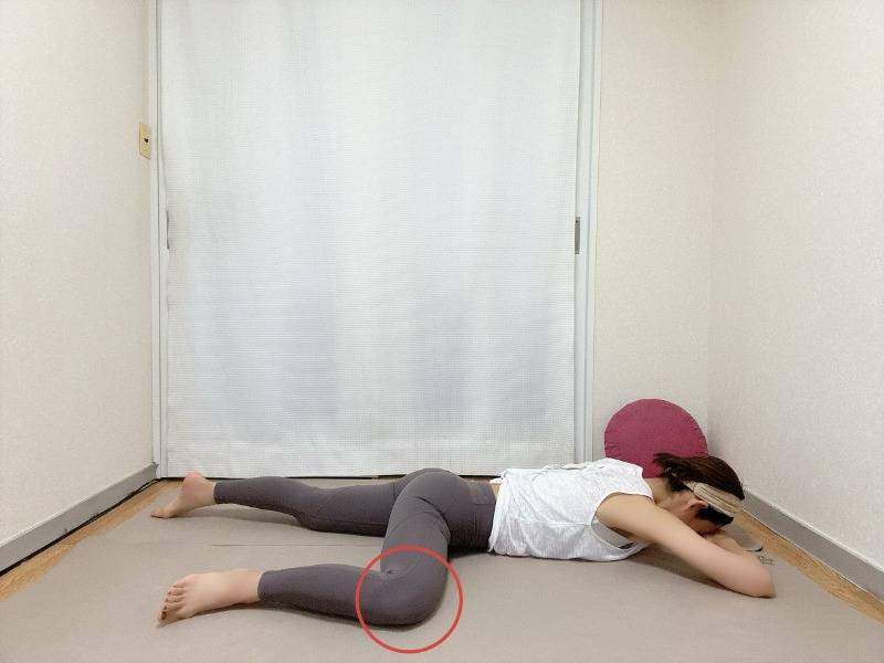 うつ伏せから片膝を90度に曲げて横に出した半分のカエルのポーズ