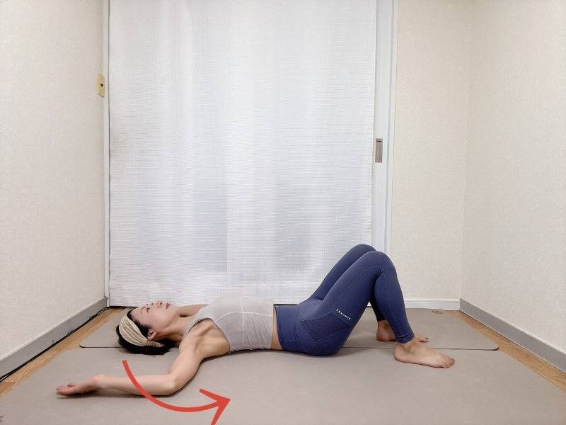 両膝を曲げ、両手を頭上に伸ばした仰向けから胸を開きながら腕を体側に戻すエクササイズ