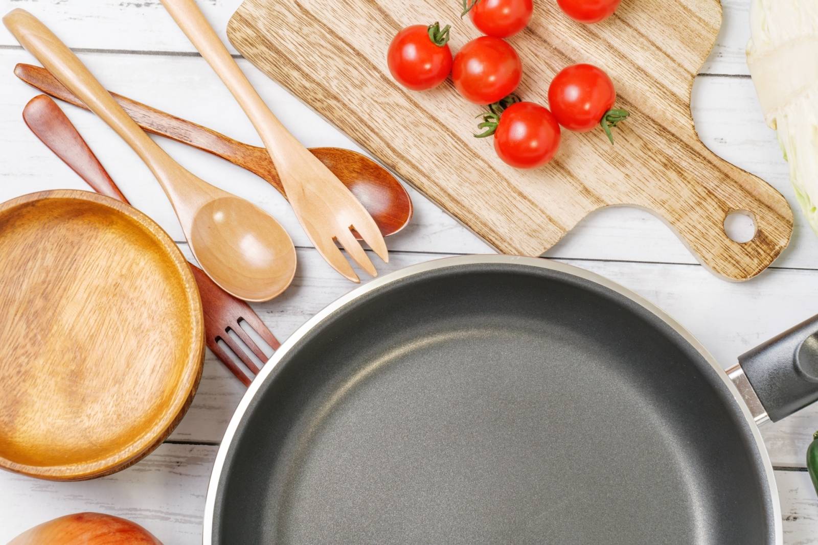 キッチンに広げられた調理器具やフライパンとミニトマト