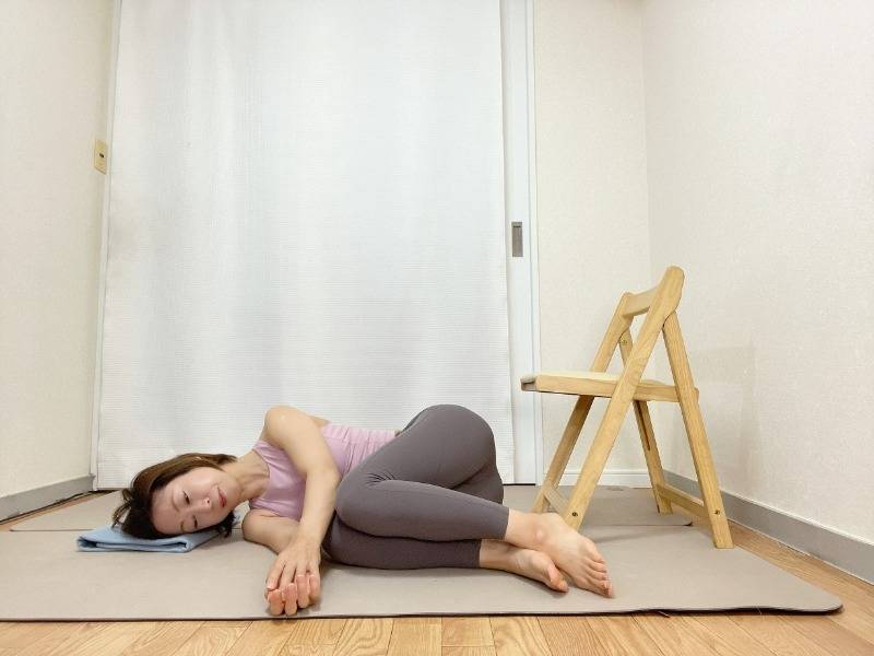 椅子の前で両膝を曲げ、横向きで寝た体勢