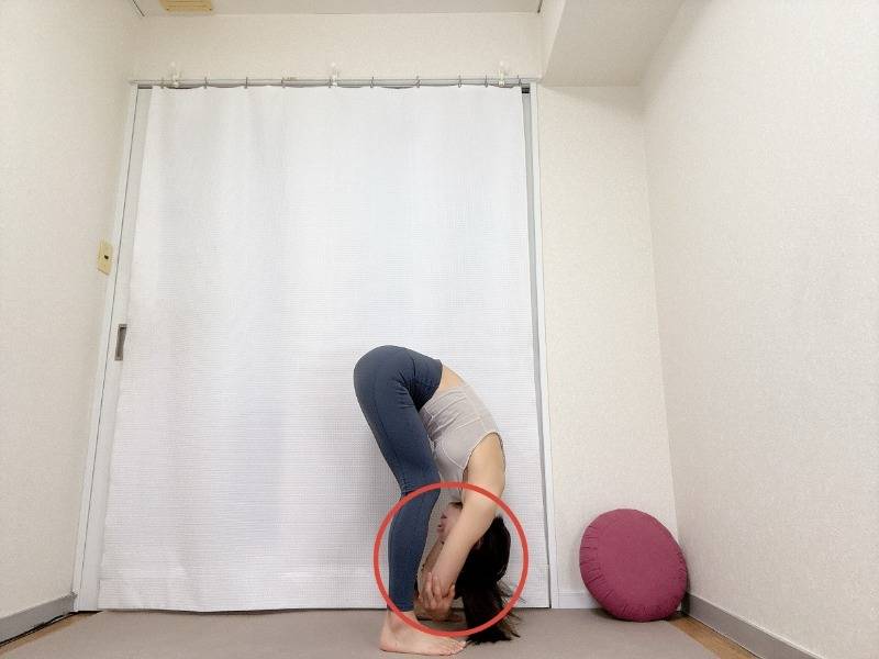 立って上体を前に倒し、肘を抱えて前屈した体勢