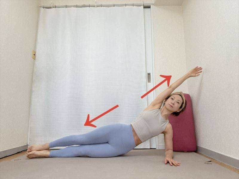 右肘を床に着いた横向き寝で、左腕を斜め上に伸ばし、左体側を広げた体勢