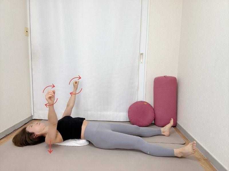 丸めたバスタオルを肩甲骨の下にセットした仰向けから両手を天井に伸ばしたまま肩甲骨をタオルに沈め、軽く握った拳で小さな円を描く、肩甲骨ほぐし
