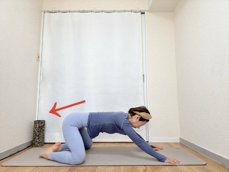 膝を広めに開いたチャイルドポーズからお尻を浮かせ背骨を伸ばしてお尻を後ろに引いた体勢