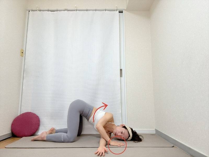 四つ這いから左脇の下に右腕を通して右肩を床に下すキャットツイストポーズ