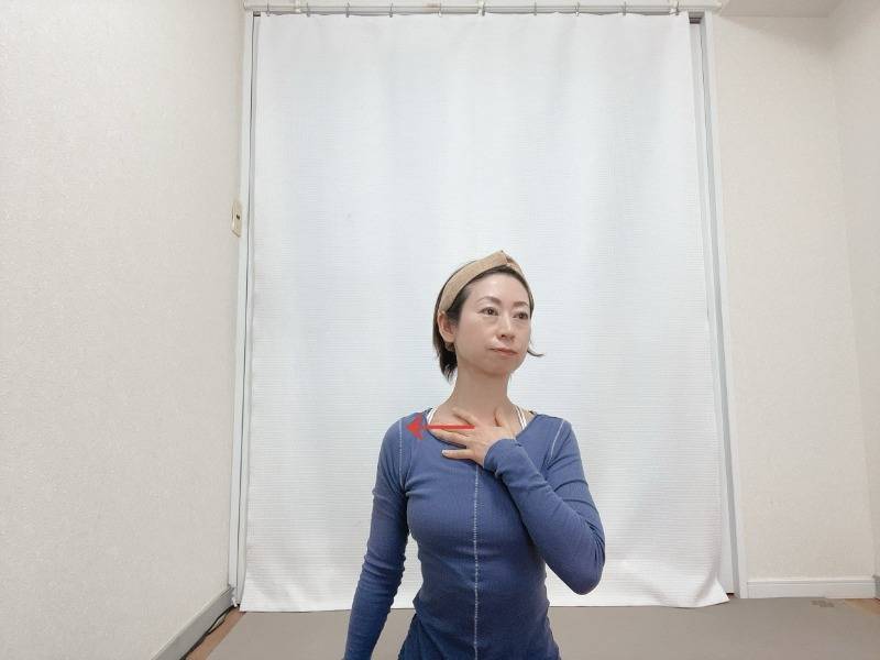 右手で左の鎖骨を中心から外側へさするセルフマッサージ