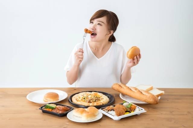 脂質多い食事を食べる女性