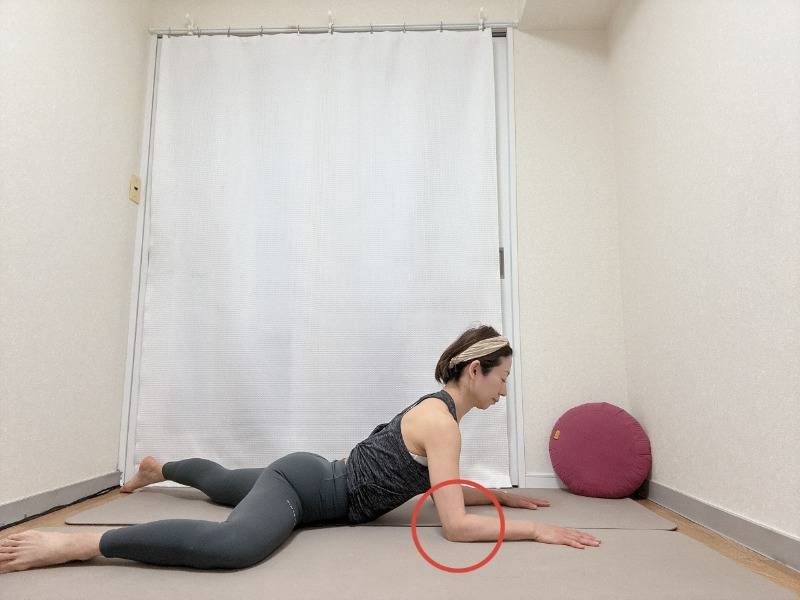 チャイルドポーズから左膝を90度に曲げて横に出し、肘をついて上体を起こした股関節のストレッチ