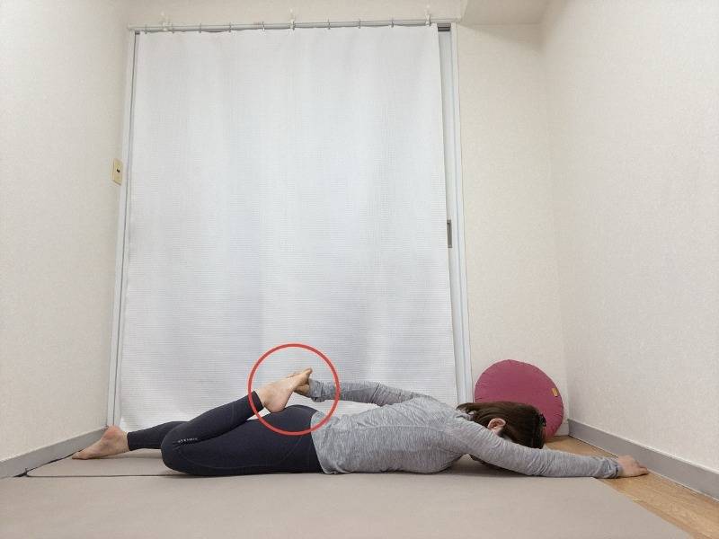 左手を前に伸ばしたうつ伏せで左膝を曲げて右手で掴んだ体勢