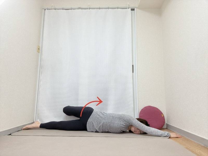 左手を前に伸ばし、左膝を曲げて右手で掴んだうつ伏せから、体をめくるように左から起こした体勢