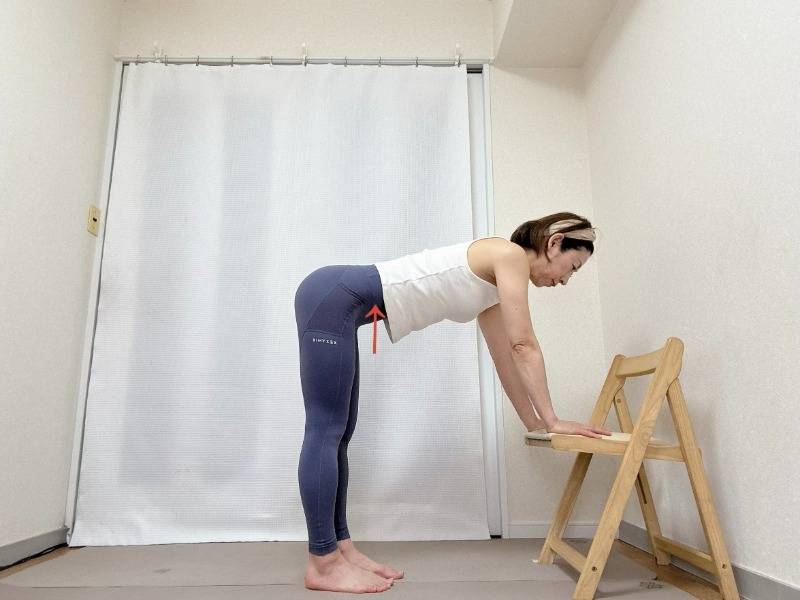 椅子の座面に手をつき、背筋を伸ばして前傾した体勢