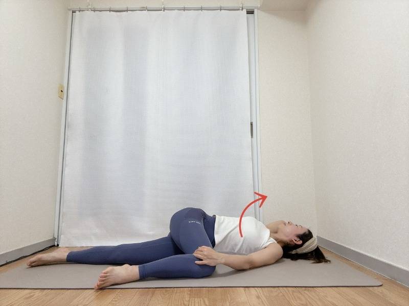 左膝を曲げ、右脚を伸ばした横向き寝から、胸を広げながら行うツイストストレッチ