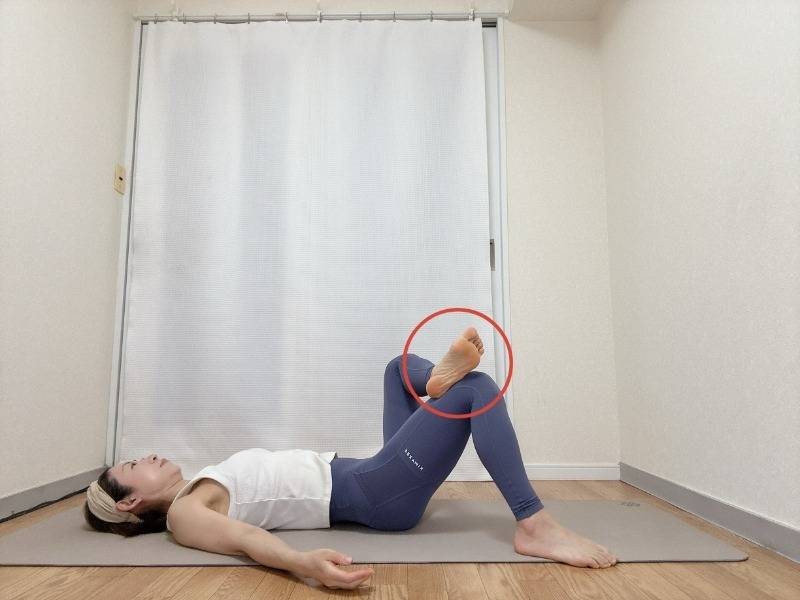 左脚を軸にして右の外くるぶしを左腿の上に乗せて4の字にした仰向けの体勢