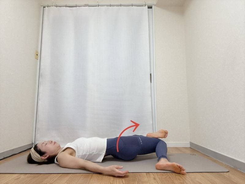 右脚を上にて4の字にした仰向けから両膝を右に倒すストレッチ