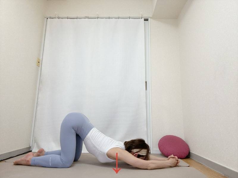 両手を組んで肘をついた四つ這いから顎を床に下し、脇・胸を開くストレッチ