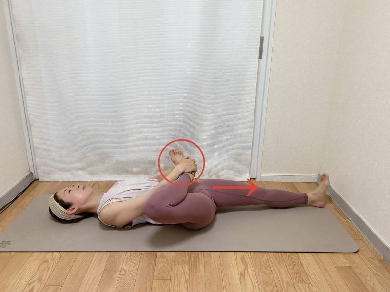 片脚をがっせきにして仰向けになり、片方の脚を伸ばしたストレッチ