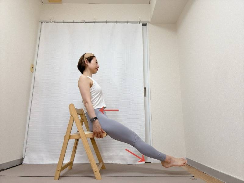 椅子の座面を持って座り、背筋をのばしたまま両脚を浮かせて斜め下に伸ばした体勢