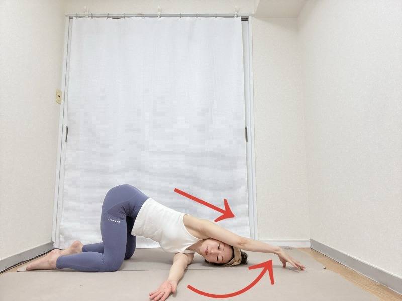 四つ這いから左脇の下へ右腕を通し、左指先で半円を描くように頭上へ伸ばしす背中のストレッチ