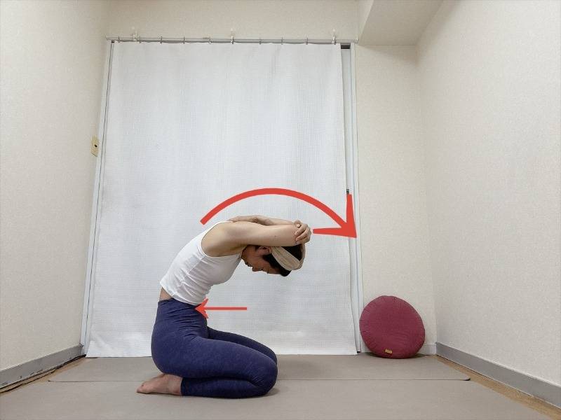 頭の後ろで左肘を右手で掴んだ正座から背骨を丸めて上体を前に傾けた体勢