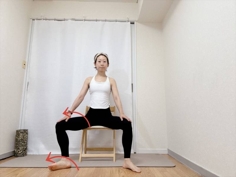 脚を広めにして椅子に座り、左膝を外側に倒した体勢