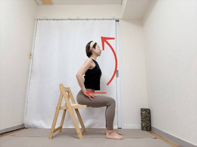 両手を脚の付け根に滑らせて胸を開く椅子に座って行うカウポーズストレッチ