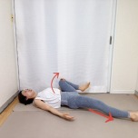 仰向けで左脚を伸ばし、右膝を胸に引き寄せ外に開いた内転筋のストレッチ