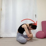 あぐらで座り、体の前で肘を抱え背骨を丸めて上体を前に傾けた体勢