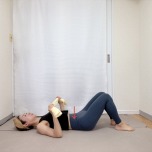 両手でタオルの端を持ち、膝を立てた仰向けで寝た体勢