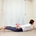 うつ伏せから、両手を後ろへ伸ばし、上体と脚を床から浮かせたバッタのポーズ
