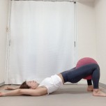 太腿の間にクッションを挟み、内転筋を刺激しながら行う橋のポーズ