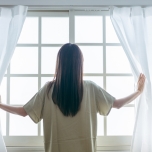 窓をあける女性の写真