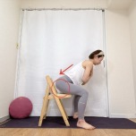 両手を胸の前でクロスして椅子の前で立ち、背筋を伸ばしたままお尻をうしろに引いて、椅子に軽く座るスクワット